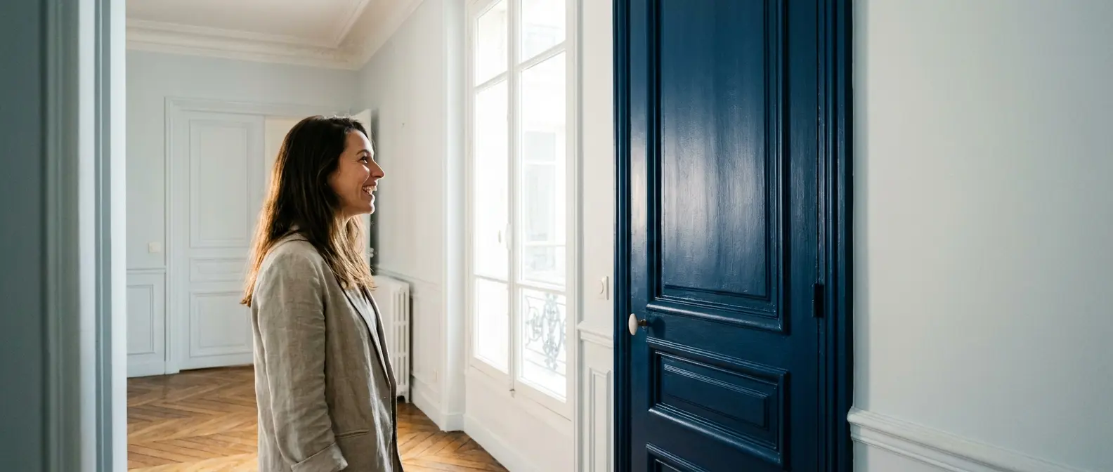 Une porte beige dans un couloir aux murs blanc cassé illustre le choix d’une teinte douce, à comparer selon le sol et la lumière.
